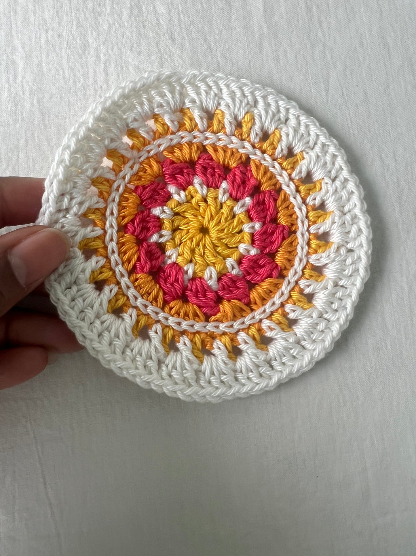 Crochet mini mandala art coasters in lemon, creme, strawberry, and mango. (Sold as 2-piece sets: you select 2 pieces. Specify the center color and petals. Pick 2 offering.)